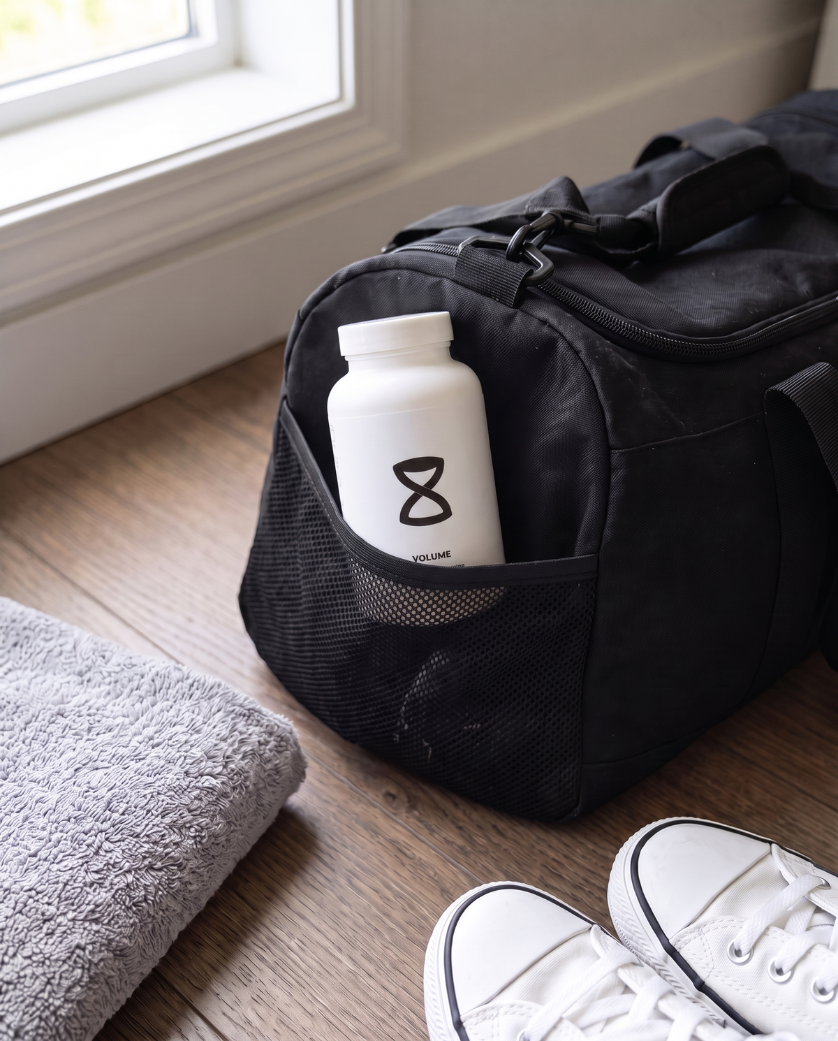 A white supplement bottle in the side pocket of a gym bag